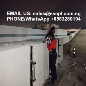 Worker in a red shirt installing a barrier in a dim tunnel; contact info at top: sales@ssepl.com.sg, +65 83280194.