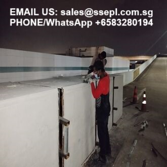 Night-time construction site with two workers inspecting white concrete panels; overlay shows contact email and WhatsApp number for sales.