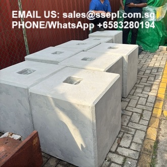 Row of hollow, precast concrete blocks outdoors, each with a square central hole; contact text for sales visible on the image.