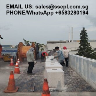 Rooftop construction scene with workers placing concrete blocks and orange traffic cones; contact email and phone number are displayed at the top of the image.