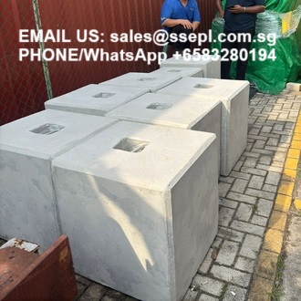 Row of gray hollow concrete blocks on a paved surface with a contact email and phone number overlaid.