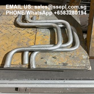 Bent metal tubing on a yellow workbench with sales email and WhatsApp phone number across the top.